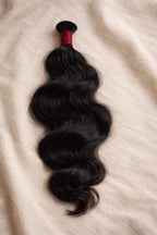 100 grams of premium Wavy Natural black Raw Indian Bulk Hair from BigLove, featuring natural, unprocessed waves perfect for high-end braiding and custom hair installations.