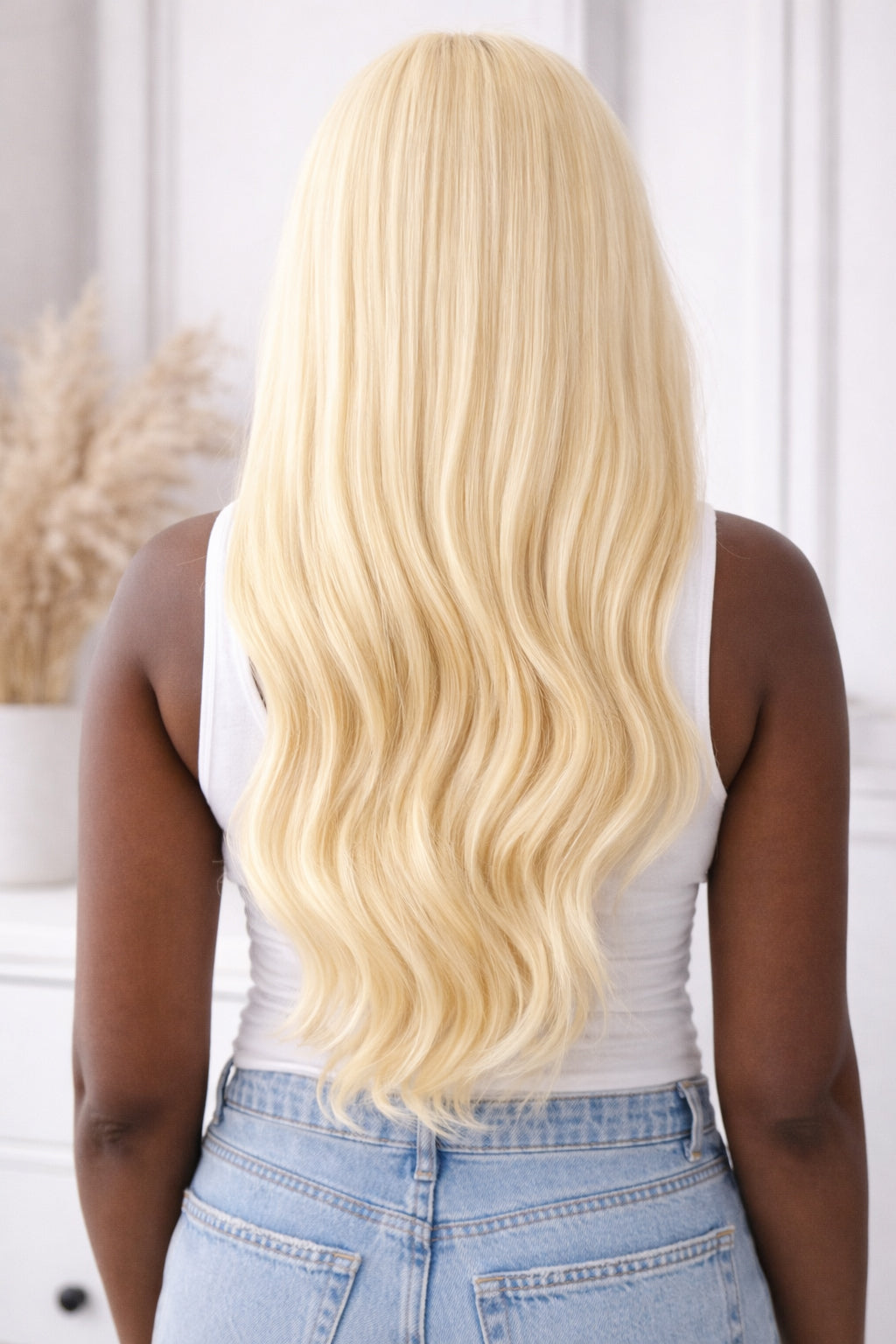 rear view of an African American lady wearing Blonde wavy Raw Indian Hair Bundles