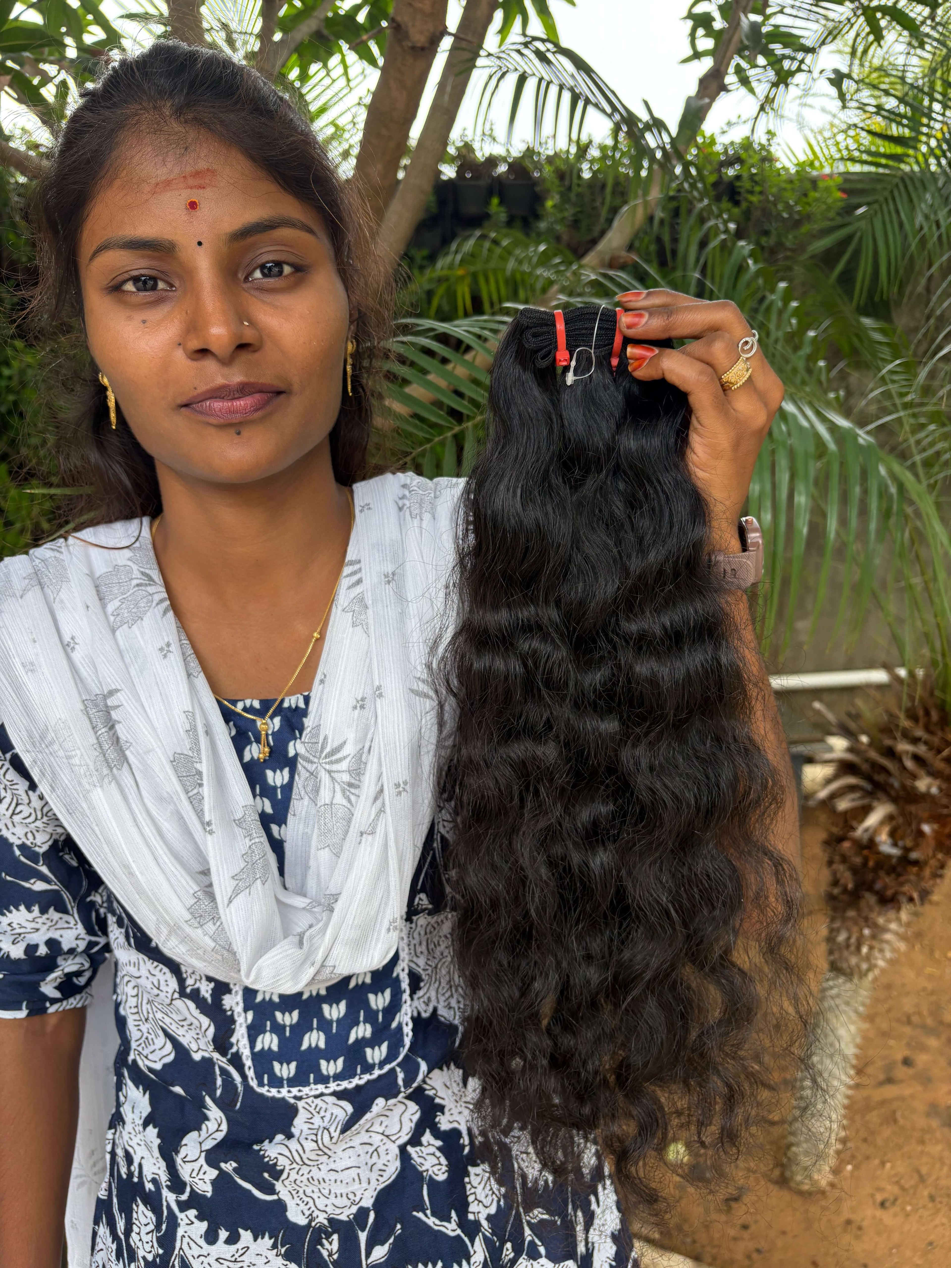 Close-up of curly raw Indian hair showing defined ringlets and natural low-luster sheen.