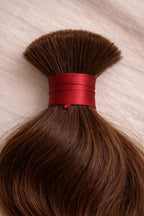 Close-up of natural brown wavy Straight Raw Bulk Indian Hair texture, highlighting the natural brown color, healthy luster and cuticle-aligned strength of single-donor, temple-sourced human hair.