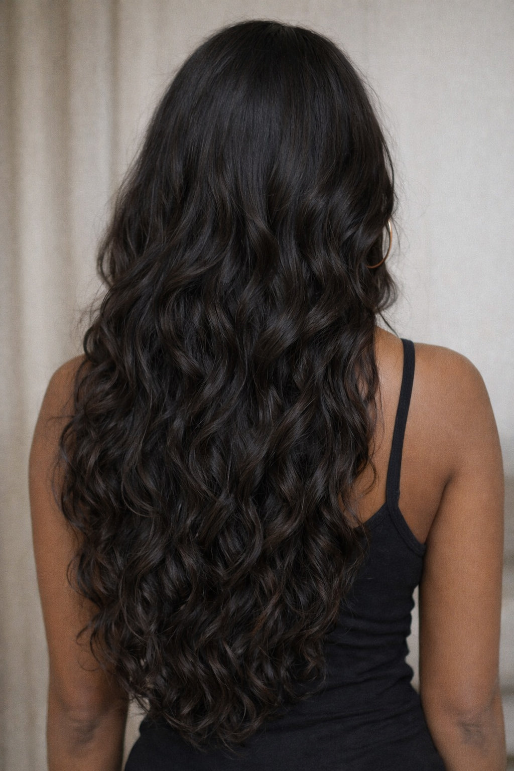 Natural wavy raw Indian hair extensions showing movement and bounce, superior to SGI hair in longevity and quality.