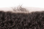 Close-up of high-definition (HD) transparent lace on a curly raw Indian hair frontal, demonstrating the ultra-thin material designed for undetectable "scalp-like" blending.