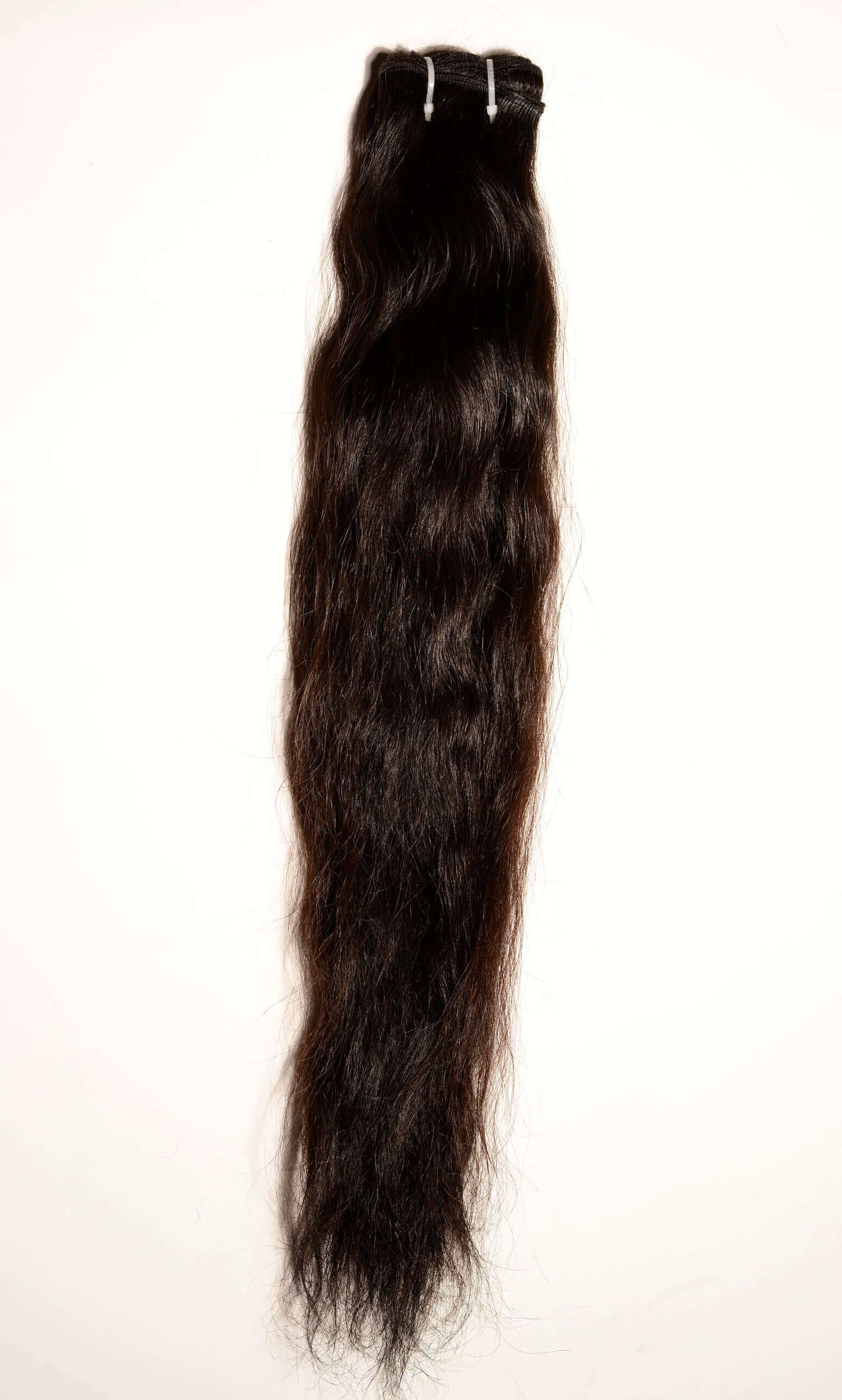 Raw Indian hair sample held under natural light to showcase the authentic, healthy luster of unprocessed temple hair.