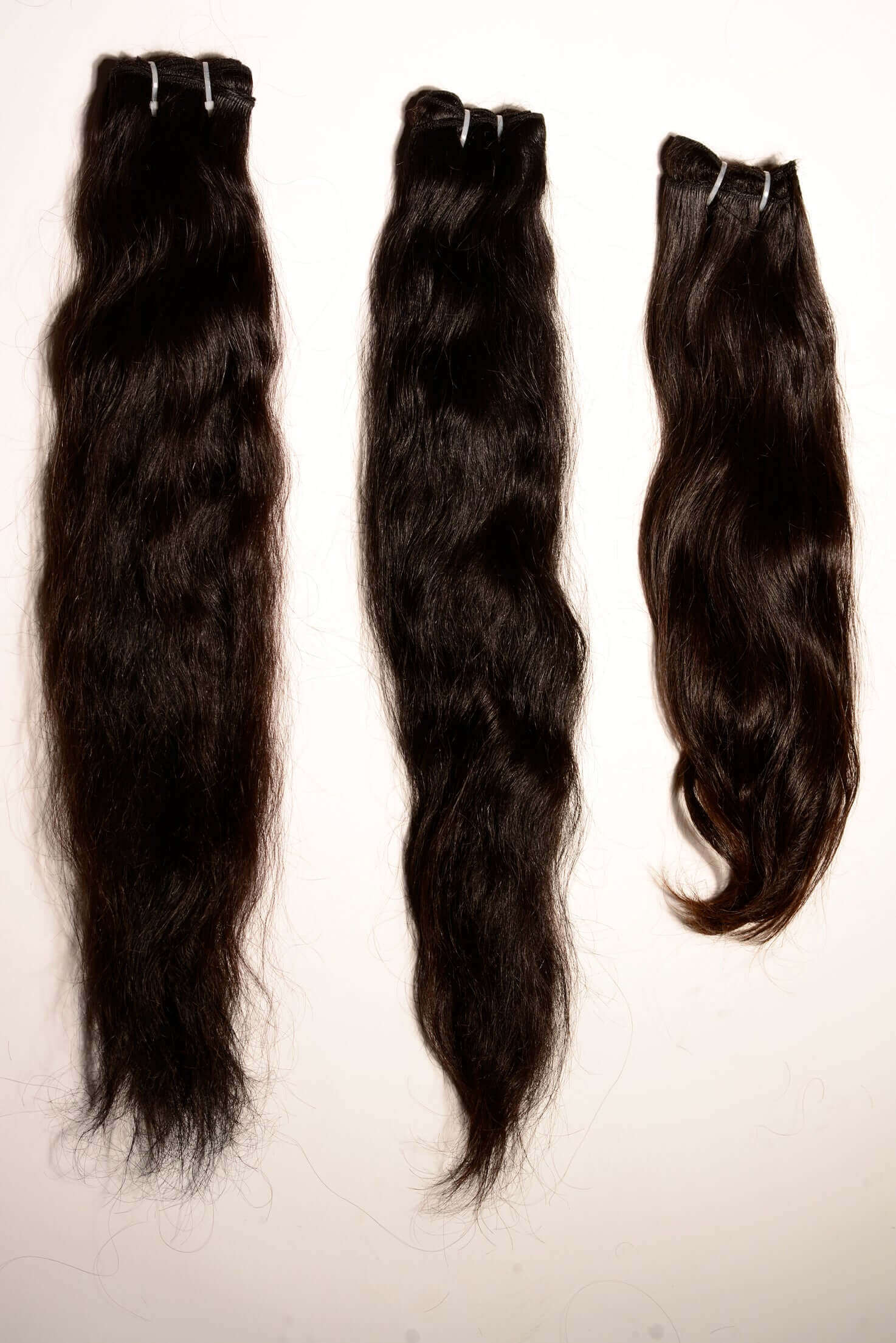 Detailed view of raw Indian hair samples demonstrating intact cuticles and reinforced weft construction for long-term durability.